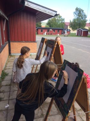 Bild på elever som målar utomhus
