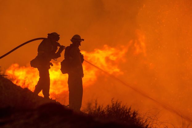 Bild på räddningspersonal som släcker en brand.