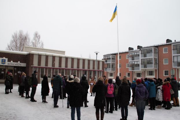 Bild på människor utanför kommunhuset med den ukrainska flaggan upphissad.