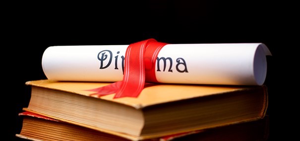 Bild på ett ihoprullat diplom som ligger på en bok.