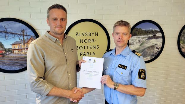 Johan Dahlqvist, kommunalråd och Andreas Nyberg, lokalpolisområdeschef Piteå älvdal tar i hand och håller i dokumentet Medborgarlöfte.