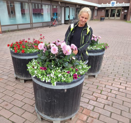 Bild på Jennie Lundberg när hon arbetar med blommor utanför kommunhuset.