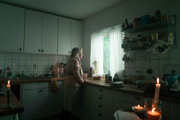 Äldre kvinna i kök utan el.