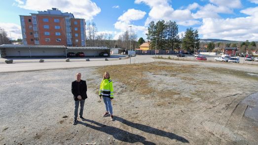Tomas Egmark och Sofia Lundberg på den lediga centrumtomten. I bakgrunden det kooperativa flerbostadshuset. Foto Peter Lundberg