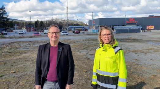 Tomas Egmark, kommunalråd och Sofia Lundberg, samhällsstrateg på den lediga centrumtomten. I horisonten Kanisbacken. Foto Peter Lundberg