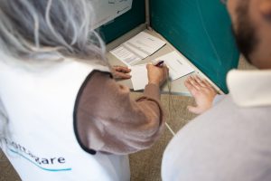 Bilden visar en röstmottagare som hjälper en väljare bakom valskärmen