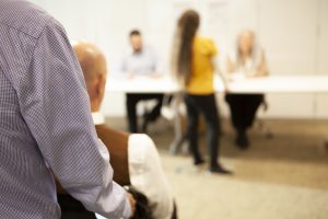 bilden visar en väljare i rullstol som väntar på att få lämna in sina valkuvert till röstmottagaren