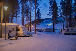 Pistmaskin kör uppför Kanisbacken. I förgrunden del av vintercampingen.