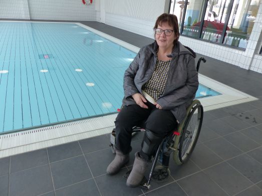 Inger Berglund sitter i rullstol vid varmvattenbassängen.