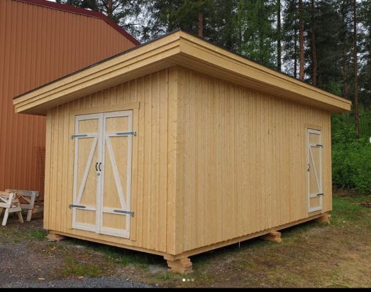 En omålad lite större förrådsbyggnad.
