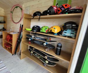 Bild på skateboards och hjälmar som ligger på en hylla.