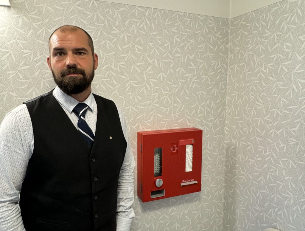 Skolchef Jonas Wallin bredvid mensautomaten.