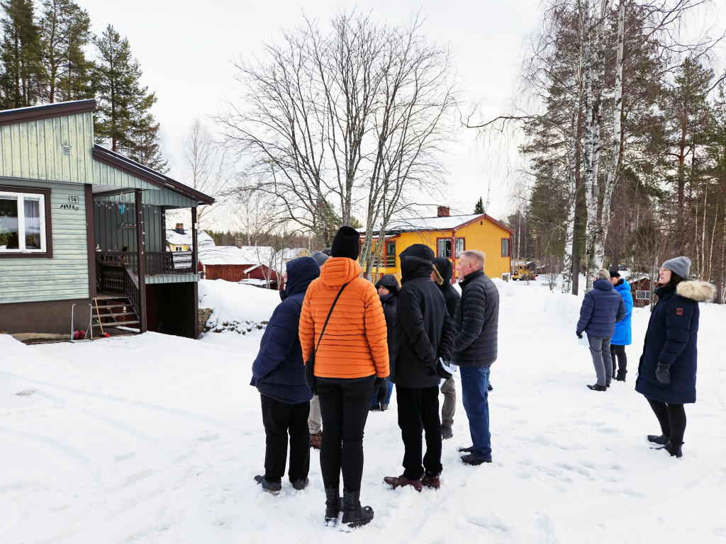 Bild på flertalet personer som pratar utomhus.