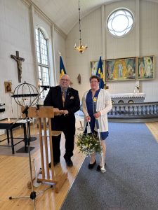 Göran Stenlund representant för Älvsbyalliansen delar ut flagga och ampel till älvsbypärlan Camilla Åhlund.