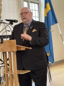 Göran Stenlund representant för Älvsbyalliansen pratar om trygghet och delar ut flagga och ampel till en älvsbypärla.