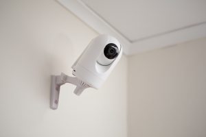 Bilden visar en trygghetskamera som sitter upphängd på väggen.