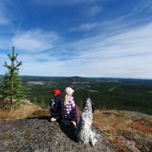 Bild som visar två barn och en hund på ett berg.