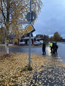 Bilden visar Polis och personer som går tillsammans på ett kvarter.