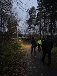 Bilden visar en mörk gångväg och personer som går tillsammans.