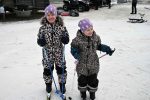 bilden visar två mindre flickor på längdskidor och i matchande leopard overaller och lila mössor som väntar på att få åka barnens vasalopp på kanisdagen 2026
