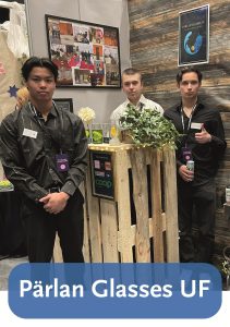 Bild på tre killar som står vid en monter med texten Pärlan Glasses UF.