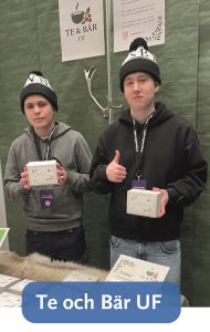 Bild på två killar som står vid en monter med texten Te och Bär UF.