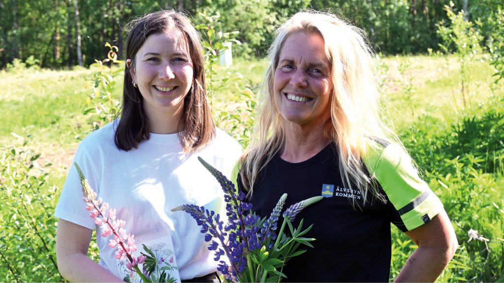 bilden visar Filippa och Jennie håller i blomstrande lupiner ute i grönskan