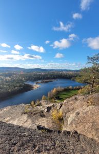 Bilden visar Piteälven sett från ett berg. Det är sommar och soligt.