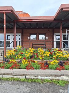 Bilden visar en blommuppsättning utanför en tegelbyggnad.